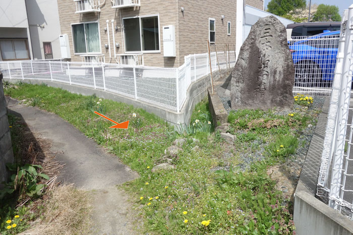 草地が水路跡と石碑